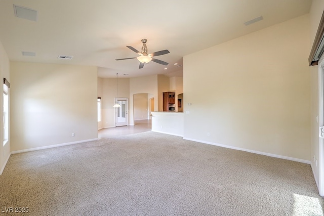 spare room featuring light carpet, high vaulted ceiling, and ceiling fan