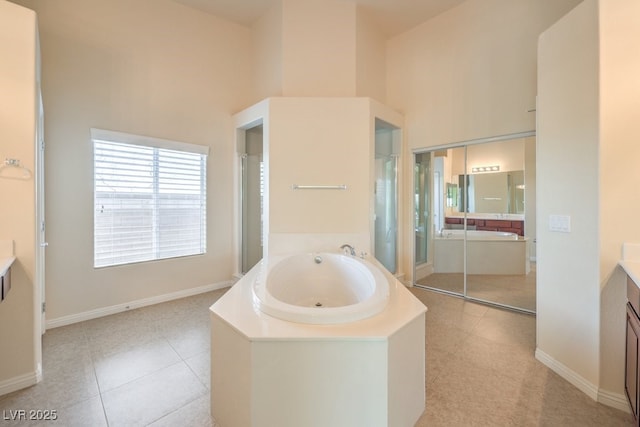 bathroom with a towering ceiling, vanity, plus walk in shower, and tile patterned flooring