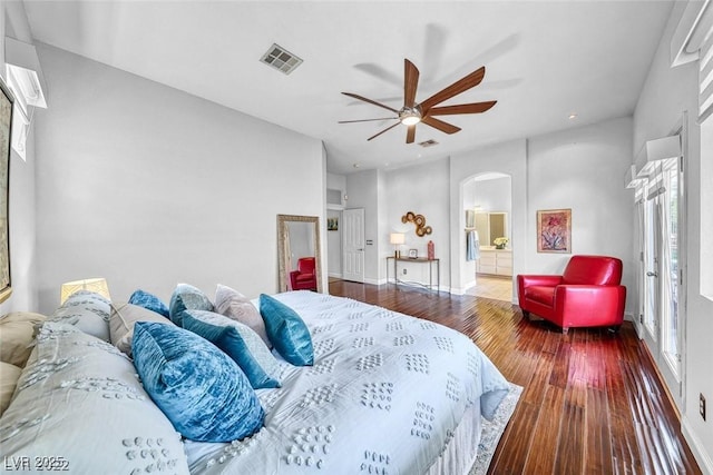 bedroom with wood-type flooring, ceiling fan, and ensuite bath