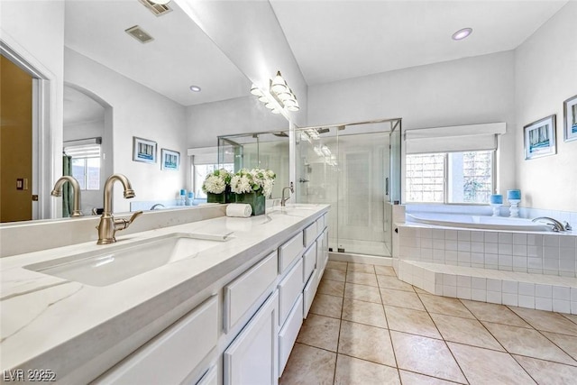 bathroom featuring tile patterned flooring, vanity, a wealth of natural light, and plus walk in shower