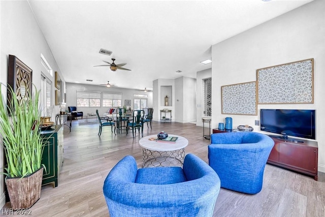 living room with wood-type flooring and ceiling fan