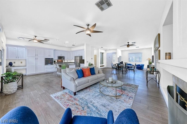 living room featuring ceiling fan and light wood-type flooring