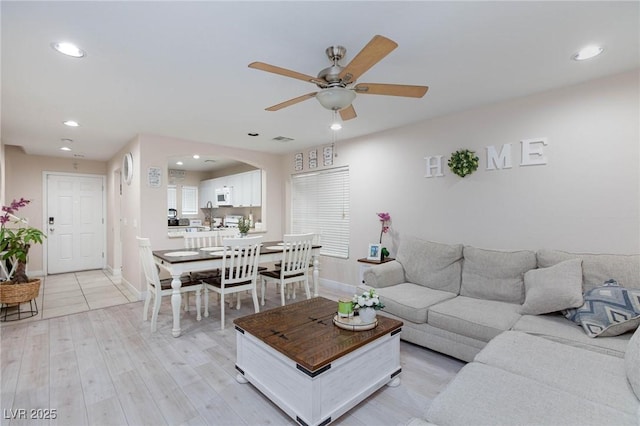 living room featuring ceiling fan and light wood-type flooring