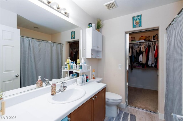 bathroom featuring vanity, hardwood / wood-style floors, and toilet