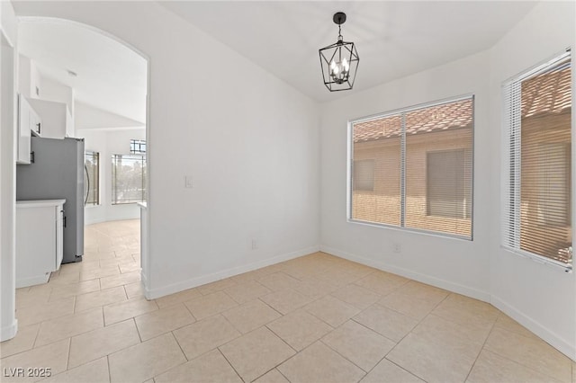 unfurnished dining area with lofted ceiling, a chandelier, and light tile patterned flooring