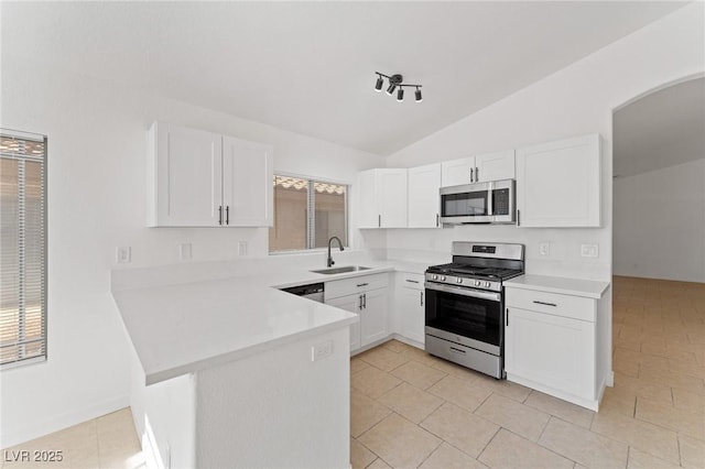 kitchen with stainless steel appliances, sink, white cabinets, and kitchen peninsula