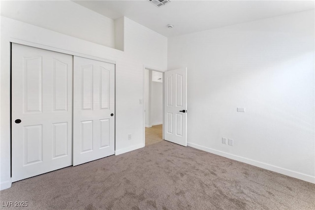 unfurnished bedroom with carpet floors, high vaulted ceiling, and a closet