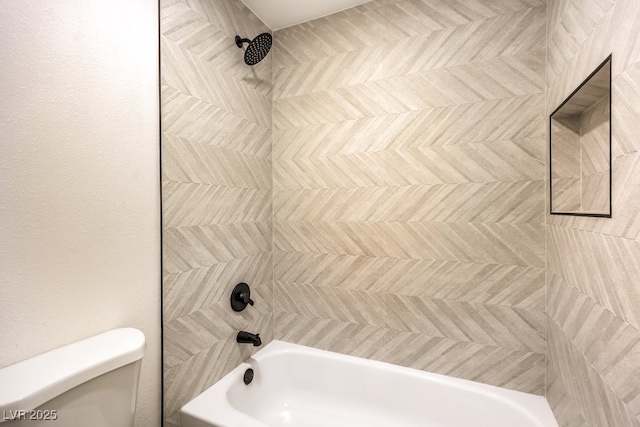 bathroom featuring toilet and tiled shower / bath combo