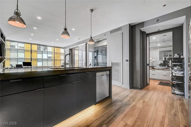 kitchen with light hardwood / wood-style flooring, sink, stainless steel dishwasher, and decorative light fixtures