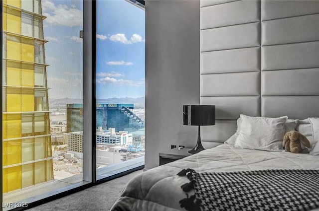 bedroom with access to outside, expansive windows, and carpet flooring