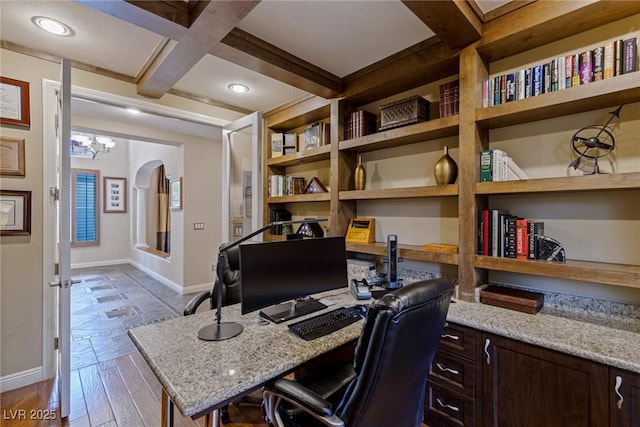 office area with built in desk, beamed ceiling, coffered ceiling, light hardwood / wood-style floors, and built in shelves