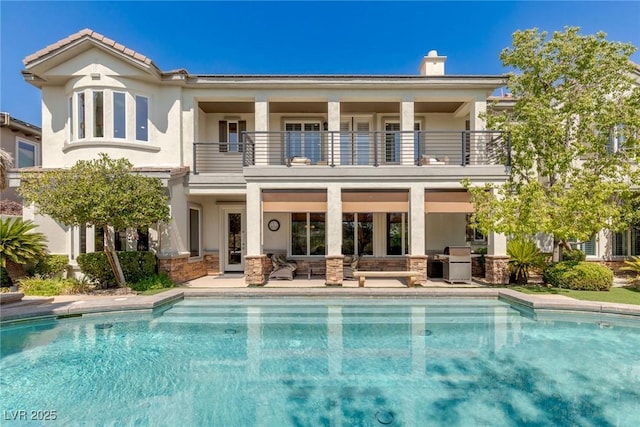 rear view of property featuring a balcony and a patio