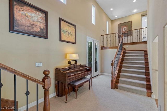 misc room featuring light carpet, a towering ceiling, and french doors