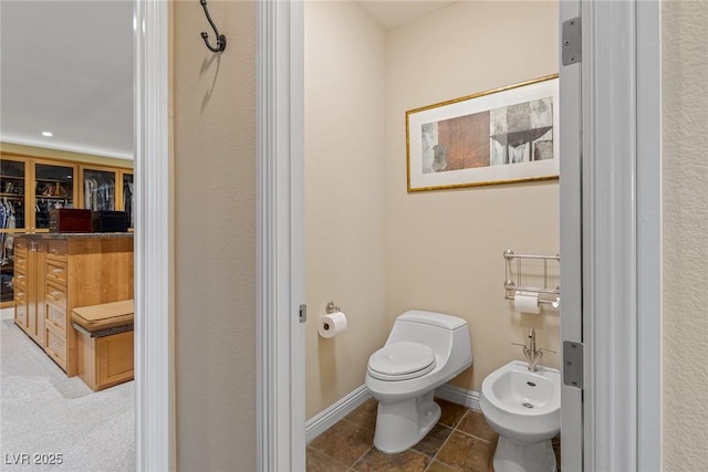 bathroom with tile patterned flooring, a bidet, and toilet