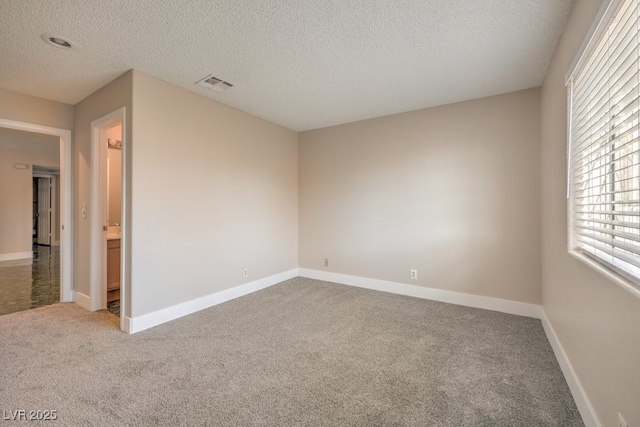 carpeted spare room with a textured ceiling