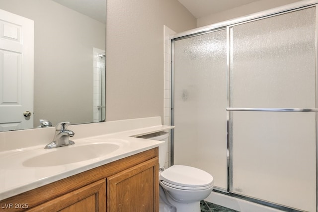 bathroom with vanity, a shower with door, and toilet