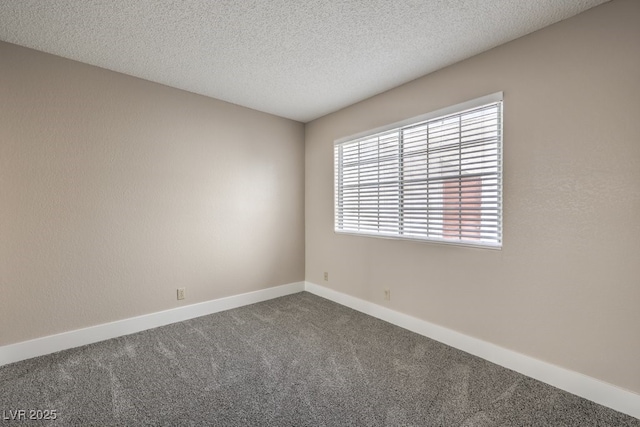 carpeted empty room featuring a textured ceiling