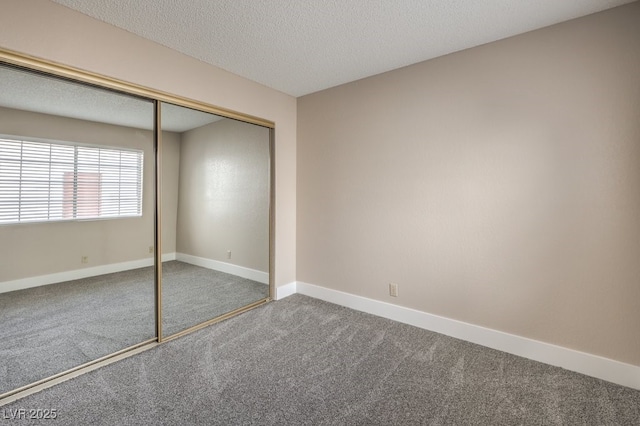 unfurnished bedroom featuring carpet floors, a closet, and a textured ceiling