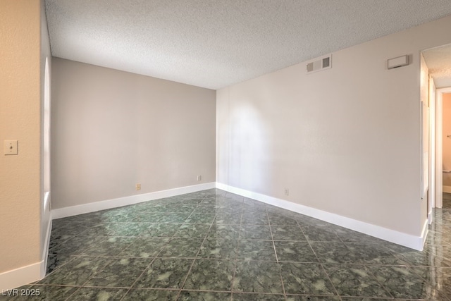 unfurnished room with a textured ceiling