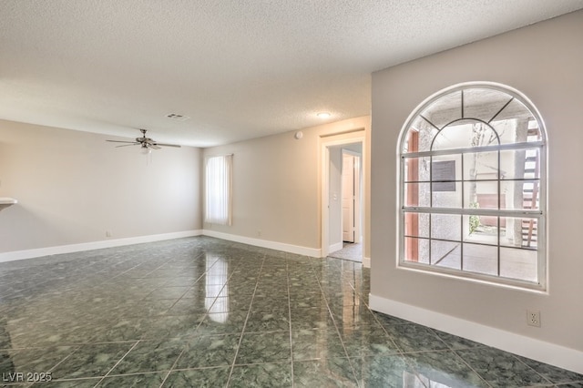 spare room with a textured ceiling and ceiling fan