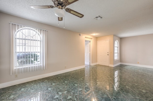 unfurnished room featuring ceiling fan and a textured ceiling