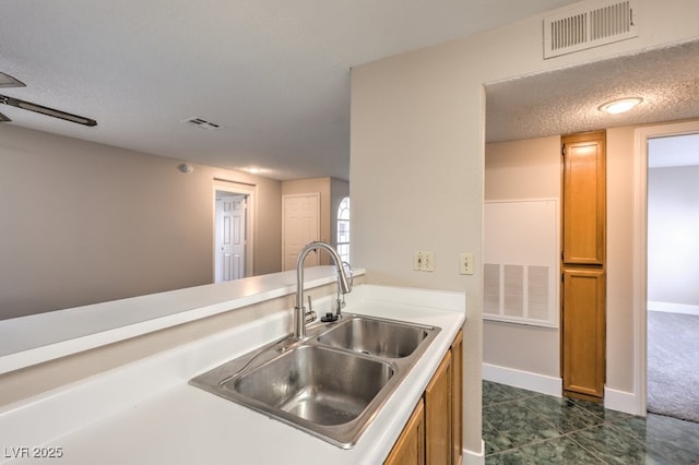 kitchen featuring sink and a textured ceiling