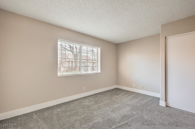 empty room with carpet floors and a textured ceiling