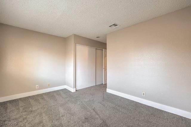 carpeted spare room with a textured ceiling