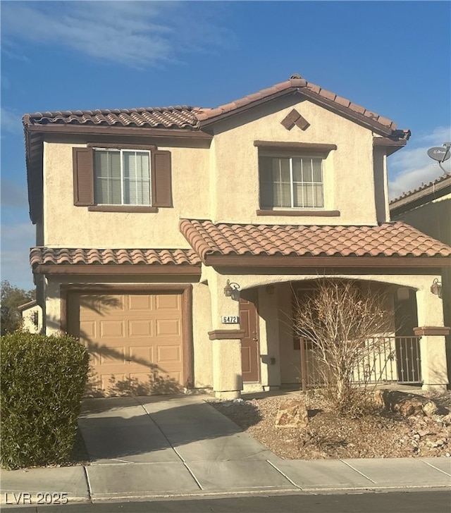 mediterranean / spanish house with a garage and covered porch