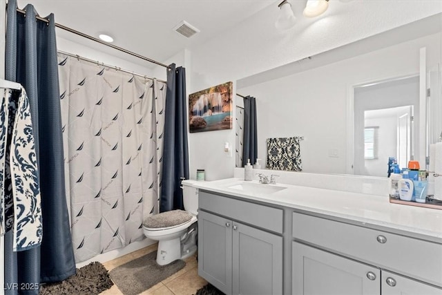 bathroom with tile patterned flooring, vanity, and toilet