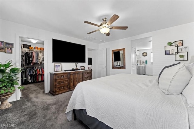 carpeted bedroom featuring ensuite bath, a walk in closet, a closet, and ceiling fan