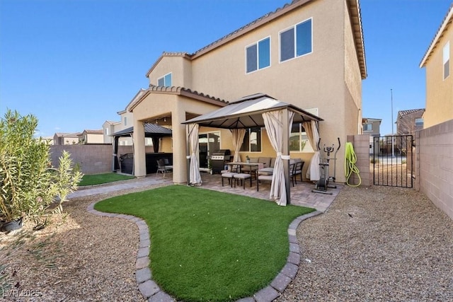 back of property with a gazebo, a lawn, and a patio area