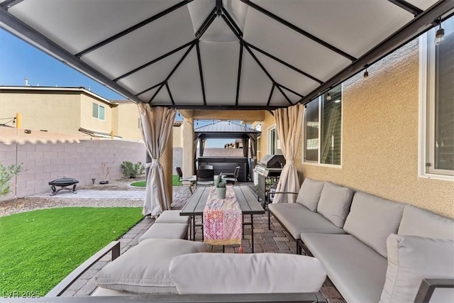 view of patio with area for grilling, a gazebo, and an outdoor hangout area