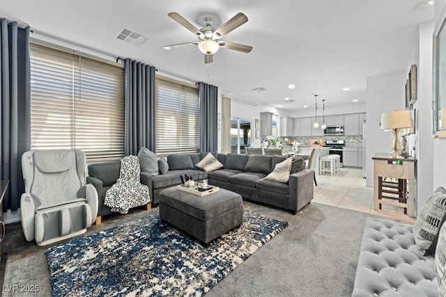 carpeted living room with ceiling fan