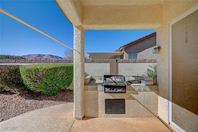 view of patio featuring an outdoor kitchen and a mountain view