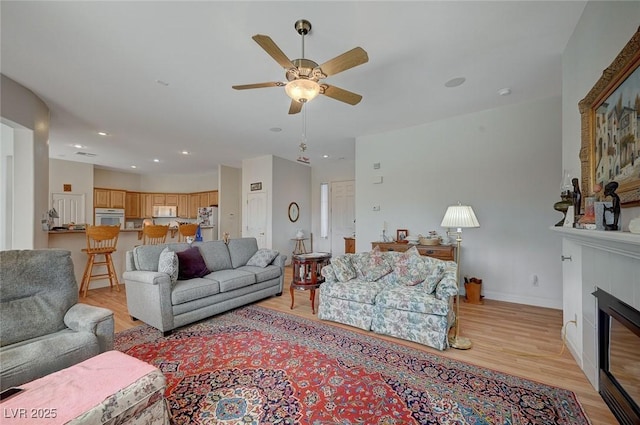 living room with ceiling fan and light wood-type flooring