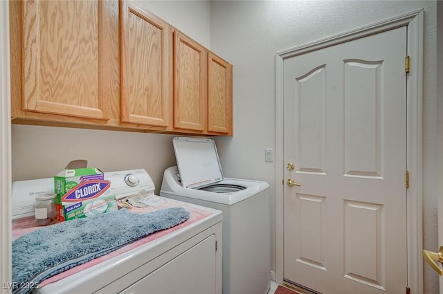 washroom featuring washing machine and dryer and cabinets