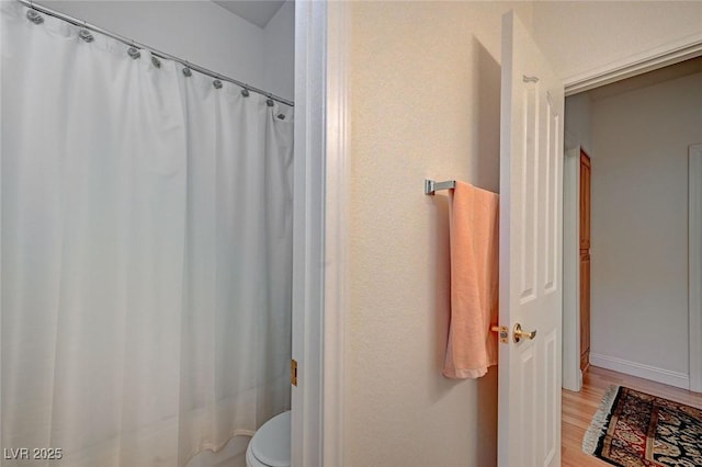 bathroom featuring hardwood / wood-style floors and toilet