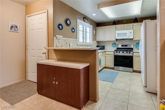 kitchen featuring light tile patterned flooring, white appliances, and decorative backsplash