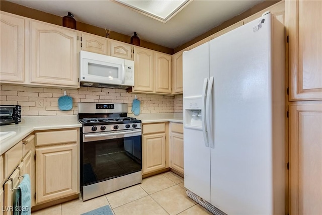 kitchen with light tile patterned floors, white appliances, and decorative backsplash