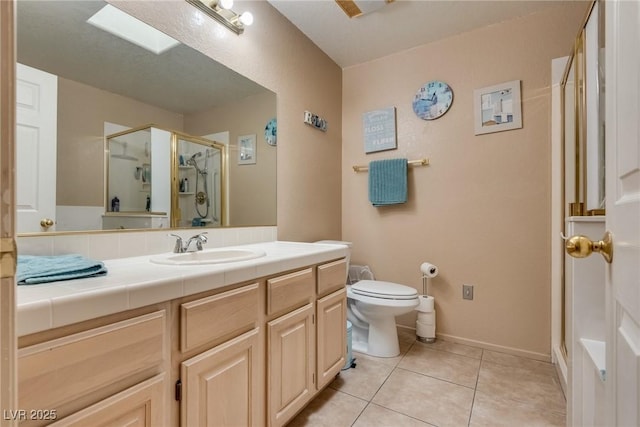 bathroom with tile patterned flooring, vanity, a shower with door, and toilet