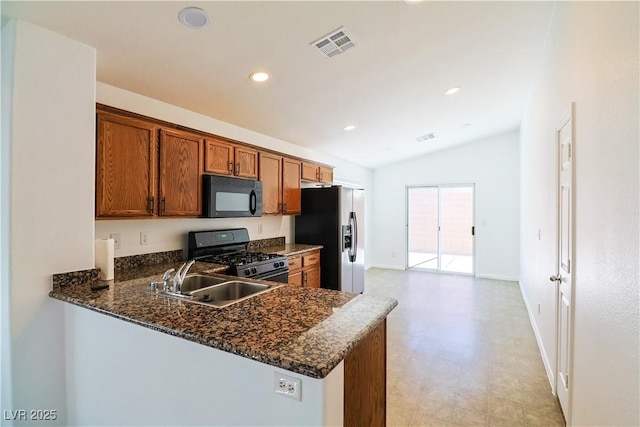 kitchen with dark stone countertops, kitchen peninsula, sink, and black appliances