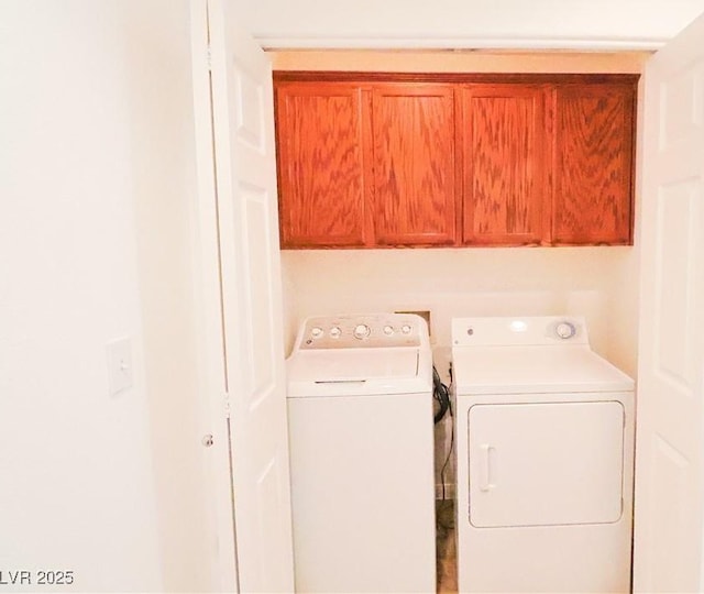 laundry room with separate washer and dryer and cabinets