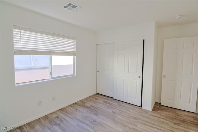 unfurnished bedroom with light hardwood / wood-style floors and a closet