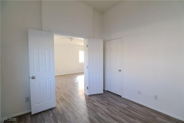 unfurnished room with hardwood / wood-style flooring and a high ceiling