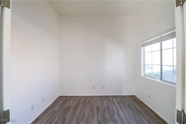 empty room featuring a barn door and dark hardwood / wood-style floors