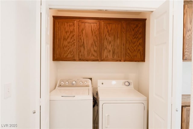 laundry room featuring cabinets and washer and clothes dryer