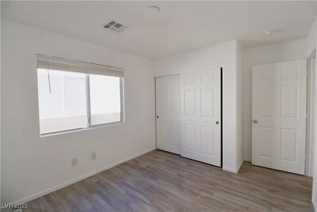 unfurnished bedroom featuring light hardwood / wood-style floors and a closet