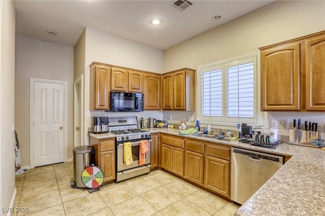 kitchen with stainless steel appliances, sink, and light tile patterned floors