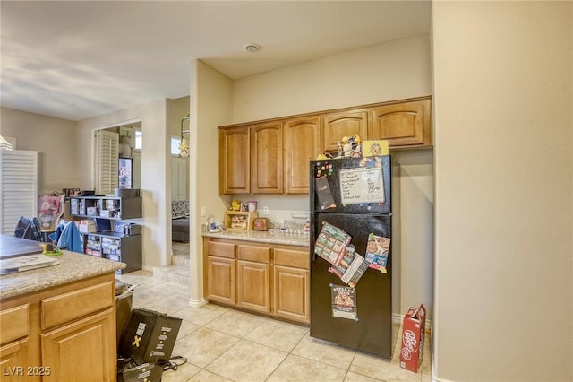 kitchen with black refrigerator and light tile patterned floors